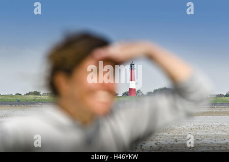 Deutschland, Schleswig-Holstein, Pellworm, Watten, Frau, Ansicht, Porträt, Leuchtturm im Hintergrund, Stockfoto