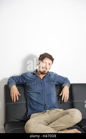 Mann, couch jung, sitzen, Blick in die Kamera, Stockfoto