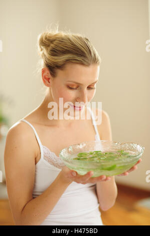 Junge Frau hält Peel mit Blütenblättern, Stockfoto