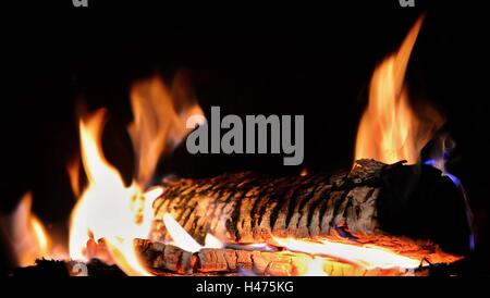 Log in Kamin auf dunklen schwarzen Hintergrund Closeup brennen. Stockfoto