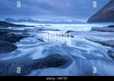 Wellen des Atlantiks Drall und Absturz über den felsigen Ufern des Gjogv auf der Insel Eysturoy, Färöer Inseln, Europa. Winter (April) 2 Stockfoto