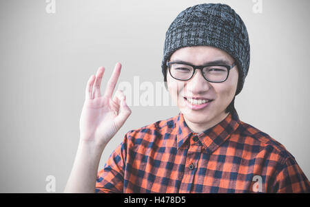 Zusammengesetztes Bild des lächelnden Hipster machen ok Sign. Stockfoto