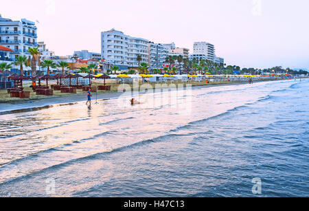 Die Abend-Strand mit den zahlreichen Hotels und Cafés auf dem Hintergrund, Larnaca, Zypern Stockfoto