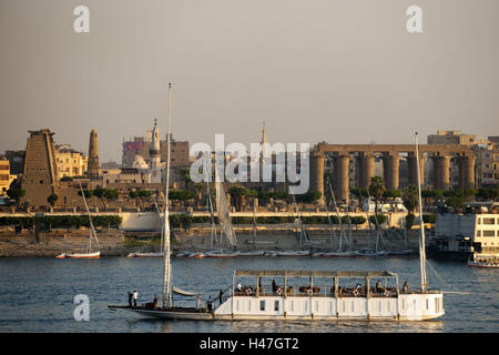 Ägypten, Luxor, Blick über den Nil im Westjordanland, Dahabije, der ein kleines Schiff mit Abfahrten für Nil-Kreuzfahrten, vor dem Luxor-Tempel, Stockfoto