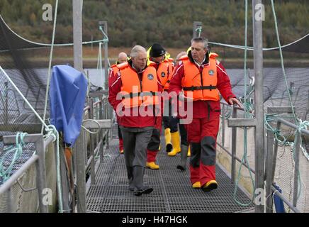 Der Prince Of Wales, bekannt als Herzog von Rothesay in Schottland, mit Steve Bracken, Marine Harvest Business Support Manager bei einem Besuch in einer nachhaltigen Lachsfarm bei Marine Harvest Loch Leven Fischfarm, am Loch Leven an überführt, von Fort William und Inverness-Shire. Stockfoto