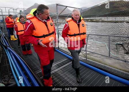 Der Prince Of Wales, bekannt als Herzog von Rothesay in Schottland, mit Steve Bracken, Marine Harvest Business Support Manager bei einem Besuch in einer nachhaltigen Lachsfarm bei Marine Harvest Loch Leven Fischfarm, am Loch Leven an überführt, von Fort William und Inverness-Shire. Stockfoto