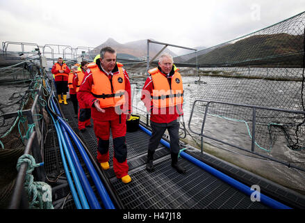 Der Prince Of Wales, bekannt als Herzog von Rothesay in Schottland, mit Steve Bracken, Marine Harvest Business Support Manager bei einem Besuch in einer nachhaltigen Lachsfarm bei Marine Harvest Loch Leven Fischfarm, am Loch Leven an überführt, von Fort William und Inverness-Shire. Stockfoto