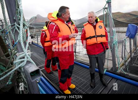 Der Prince Of Wales, bekannt als Herzog von Rothesay in Schottland, mit Steve Bracken, Marine Harvest Business Support Manager bei einem Besuch in einer nachhaltigen Lachsfarm bei Marine Harvest Loch Leven Fischfarm, am Loch Leven an überführt, von Fort William und Inverness-Shire. Stockfoto