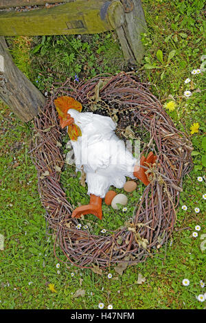 Oster-Deko, Huhn liegt auf dem Rücken im Nest, Stockfoto