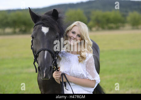 junge Frau, Pferd, Wiese, stehen, Blick in die Kamera Stockfoto