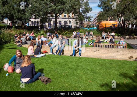 Menschen Sie genießen sonniges Wetter im St.-Andreas Kirche Park in Holborn, London England Vereinigtes Königreich UK Stockfoto