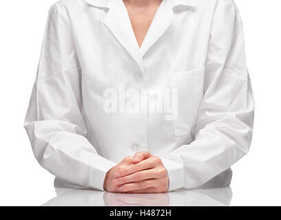 Nahaufnahme von Frau in weißem Kleid sitzt am Tisch vor weißem Hintergrund Stockfoto