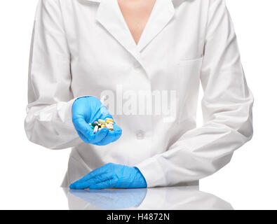 Nahaufnahme der Ärztin in medizinischen weißes Kleid und blauen sterilisierte OP-Handschuhe halten verschiedene Tabletten und Kapseln Stockfoto