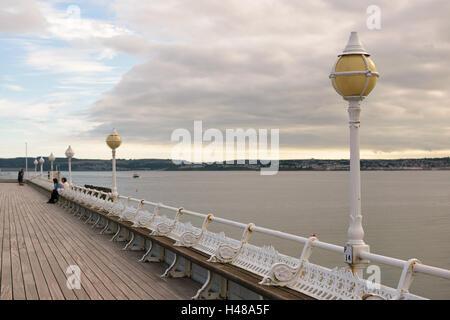 Nicht identifizierte Personen sitzen auf einer Bank auf Prinzessin Pier in Torquay, englische Riviera, Devon, England UK Stockfoto