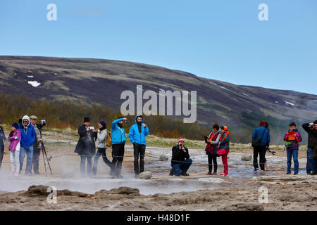 Touristen stehen herum und warten der Strokkur-Geysir zu Geysir Island ausbrechen Stockfoto