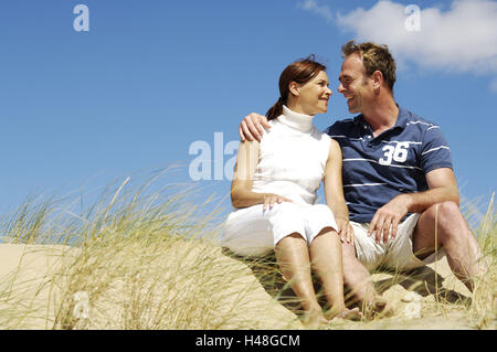 paar, Strand, Düne, sitzen, fröhlich, Blick-Kontakt Stockfoto