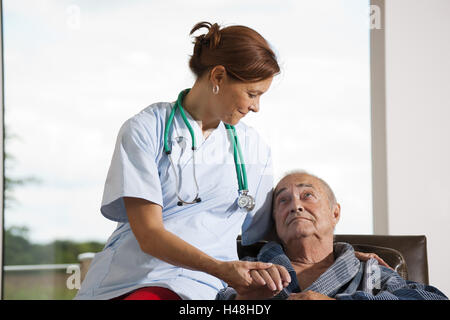 Krankenschwester hält die Hände eines Chefs, Stockfoto