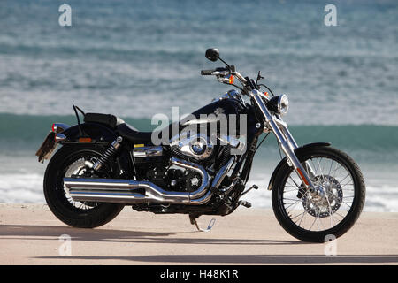 Motorrad, Cruiser, Harley Davidson Wide Glide, schwarz, Meer im Hintergrund, Seite standard rechts, Stockfoto
