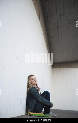 junge Frau, sitzt am Boden, Wand, schlanke, denken leider Stockfoto