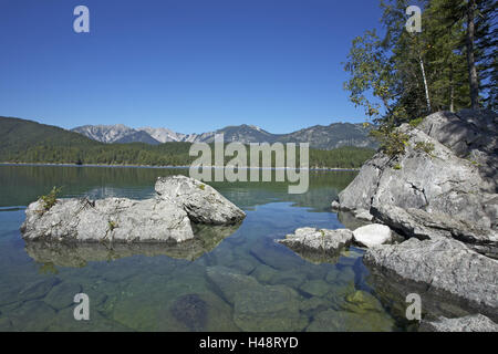 Eibsee mit Grainau nahe Garmisch-Partenkirchen, Rock am Ostufer, Blick auf Ammergebirge mit Kreuz Punkt, 2185 m, Stockfoto