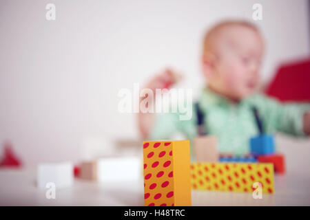 Fachwerk-Bau Steinen, Hintergrund, Kind, junge, spielen, Unschärfe, Mensch, Kind, nur, Spiel, sitzen, Tisch, Spielzeug, lernen, pädagogisch, hell, erreichen, verstehen, stapeln, bauen, verfassen, ableiten, Fähigkeiten, Fertigkeiten, Aktivität, detaillierte Schärfe, innen, Gebäude, Blöcke, Blöcke, Komponenten, modulares System, kleines Stück Holz, Entwicklung, Stockfoto