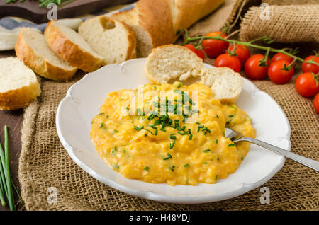 Französische Rührei mit Schnittlauch mit französischen Baguette und Mini-Tomaten Stockfoto