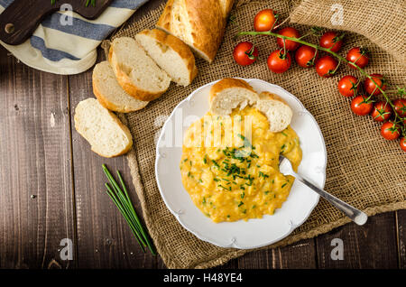 Französische Rührei mit Schnittlauch mit französischen Baguette und Mini-Tomaten Stockfoto