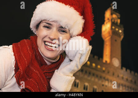 Reise voller Inspiration in der Weihnachtszeit in Florenz. Porträt von glücklich moderne touristische Frau in Weihnachtsmütze auf der Vorderseite des Stockfoto