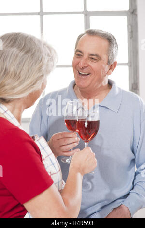 Älteres Ehepaar mit Rotwein Gläser in der Hand, Stockfoto