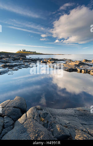 Felsige Küste mit Felsenpools bei Dunstanburgh Castle, Craster, Northumberland, England. Frühling (April) 2013. Stockfoto