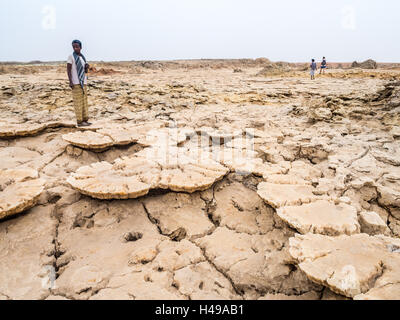 Die Menschen gehen über Mineralboden Formationen um Schwefel See Dallol, Danakil-Senke, Äthiopien, der heißeste Ort auf der Erde. Stockfoto