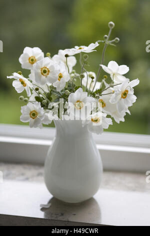 Blumenstrauß, chinesische Anemonen in weiße Vase auf Fensterbank, Stockfoto
