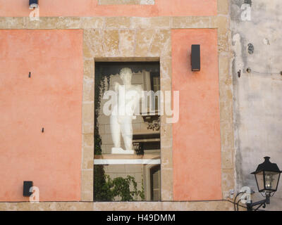 Figur in das Fenster eines Balkens, Placa Contitutio, Altstadt, Alcudia, Mallorca, Spanien Stockfoto