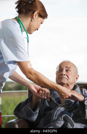 Krankenschwester hält die Hände eines Senior, Stockfoto