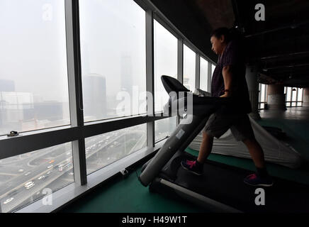 Peking, China. 14. Oktober 2016. Eine Frau tut indoor Training auf einem Laufband in Smog gehüllten Peking, Hauptstadt von China, 14. Oktober 2016. Bildnachweis: Luo Xiaoguang/Xinhua/Alamy Live-Nachrichten Stockfoto