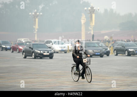 Peking, China. 14. Oktober 2016. Ein Mann mit Maske reitet auf Smog gehüllten Chang'an Avenue in Peking, Hauptstadt von China, 14. Oktober 2016. Bildnachweis: Ju Huanzong/Xinhua/Alamy Live-Nachrichten Stockfoto