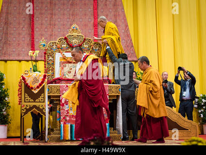 Zürich, Schweiz. 14 Okt, 2016. Mitglieder der tibetischen Gemeinschaft helfen, Seine Heiligkeit der 14 Dalai Lama bis zu seiner erhobenen Sitz an einer buddhistischen Zeremonie vor mehreren tausend Anhängern des Schweizerischen Tibeter Gemeinschaft im Hallenstadion Zürich auf. Credit: Erik Tham/Alamy leben Nachrichten Stockfoto