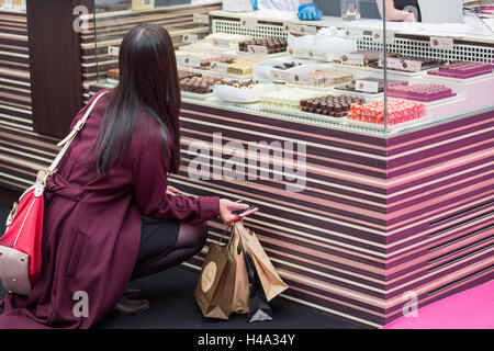 London, UK. 14. Oktober 2016. Besucher hockt die Schokolade Ion die Pralinen auf dem Stand The Chocolate Show anzusehen. Die Show findet in Olympia London, UK vom 14.-16. Oktober 2016, als das große Finale der Schokolade Woche. © Laura De Meo/Alamy Live News Bildnachweis: Laura De Meo/Alamy Live-Nachrichten Stockfoto