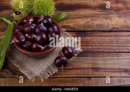 Frische Kastanien in Holzschale auf rustikalen Hintergrund. Textfreiraum Stockfoto