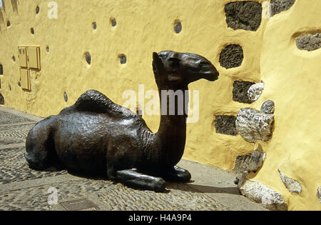 Spanien, Kanarische Inseln, Korn Canaria Agüimes, Gasse, Haus, Tier Skulptur, Dromedar, liegend, die Kanarischen Inseln, Inselgruppe, Insel, Außenwand, Architektur, Gebäude, gelb, Weg, Pflaster, Steinpflaster, Kultur, Kunst, Bronze-Skulptur, Bronze, Tier, Bestie Belastung, ruhend, Skulptur, St. Kunst im Außenbereich Stockfoto