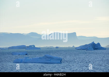 Eisberge vor verschneite Berglandschaft, O Fjord, Scoresbysund, Ostgrönland, Stockfoto