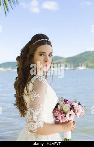 Braut mit Brautstrauß, Seitenansicht, Anzeige in die Kamera, die Hälfte portrait Stockfoto