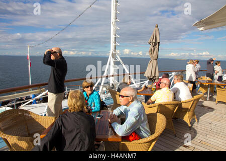 Passagiere versammeln sich auf dem Achterdeck der Windstar Cruises Segel-Cruiser Wind Surf als Schiff Segel aus Kopenhagen, Dänemark. Stockfoto