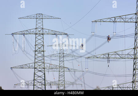 Hochspannungs-Stangen, Drähte, zwei Männer arbeiten auf energetischen Linie Anlage, Gondeln, Draht-Installation, Thüringer Wald Stockfoto