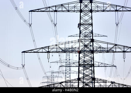 Hochspannungs-Pole, zwei Männer Klettern an einem Pol, Silhouetten, Gegenlicht Stockfoto