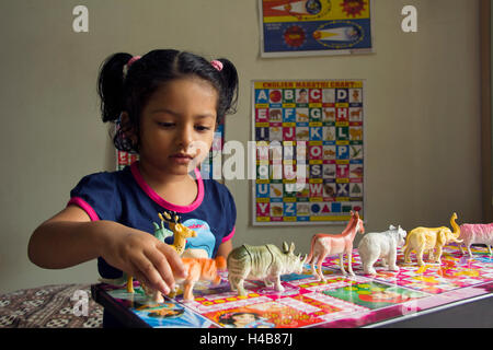 Ein Kind spielt mit tierischen Spielzeug daheim, Pune, Maharashtra, Indien Stockfoto