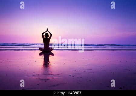 Frau praktizieren Yoga am Strand bei Sonnenuntergang in Koh Chang, Thailand Stockfoto