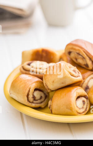 Mini-Zimtschnecken auf weißen Küchentisch. Stockfoto