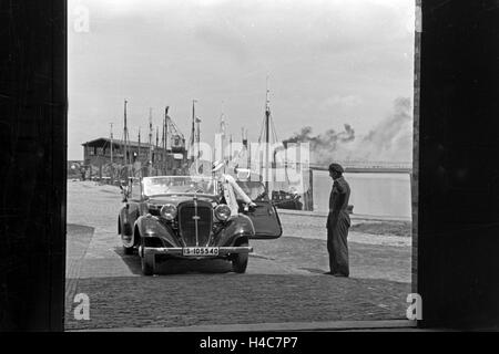 Eine Frau Fährt Ihr Audi Cabrio in Eine der Garagen am Meer in Norddeich, Deutschland, 1930er Jahre. Eine Autofahrerin ihren Audi Convertibel in eines der Parkhäuser in Norddeich, Deutschland der 1930er Jahre Stockfoto