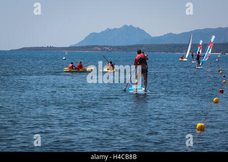 Surfer Mann Paddling an Bord unter Kanus und Windsurf aufstehen Stockfoto